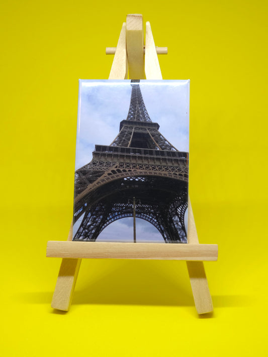 Wooden stand holding a photo of the Eiffel Tower against a yellow background