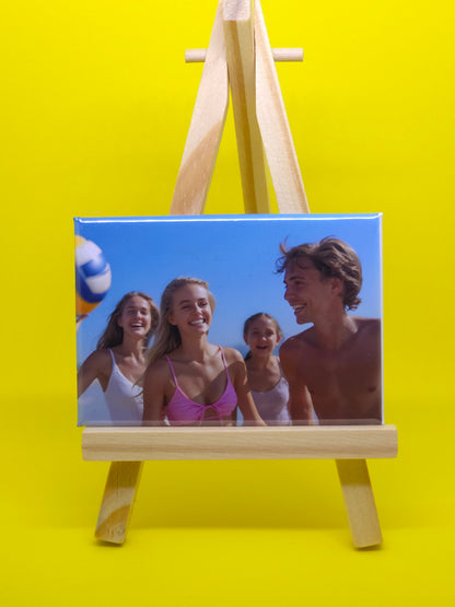 Wooden photo frame with a beach scene of three people on a yellow background