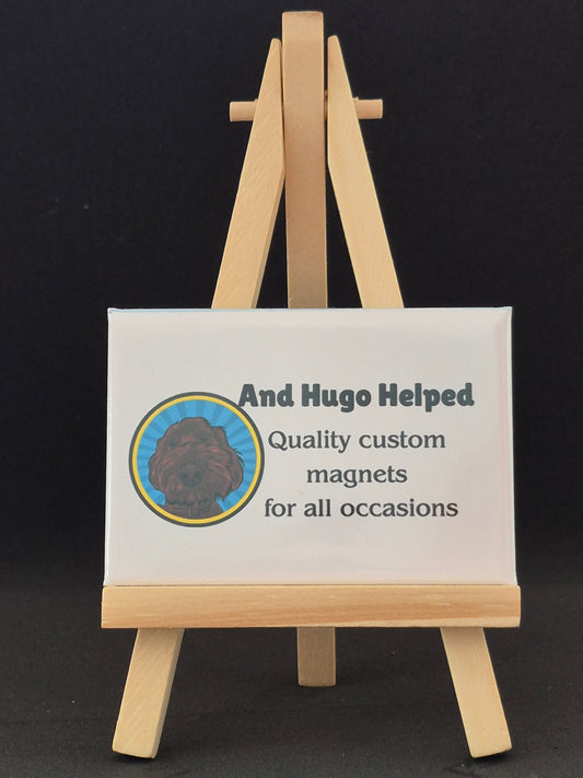 Wooden easel with a sign reading 'And Hugo Helped' on a black background
